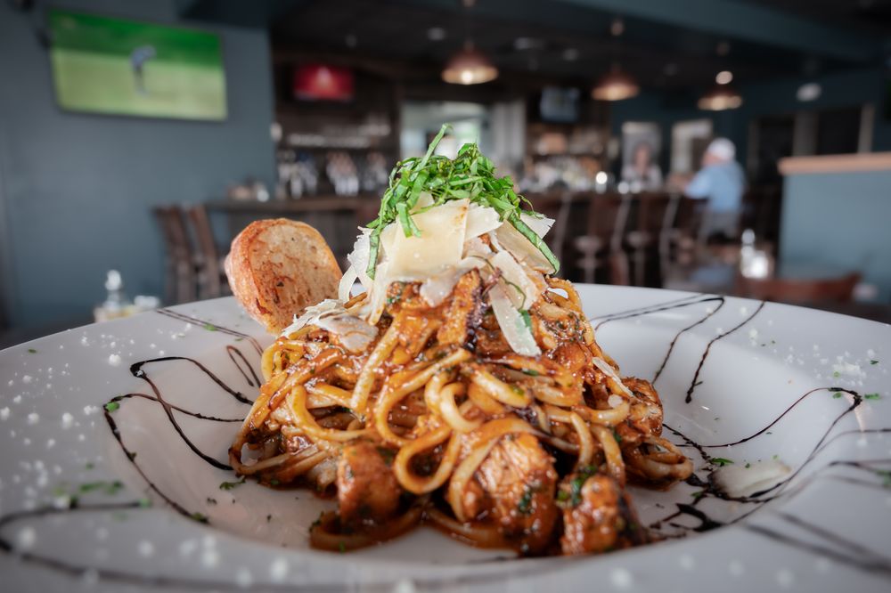 1886 Pasta plated with a view of the bar and dining room
